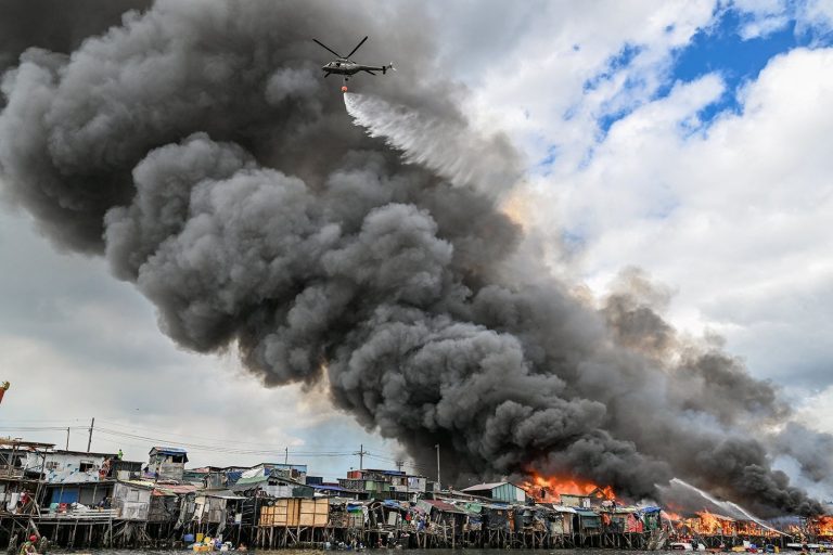 Helicoptero Da Forca Aerea Filipina Joga Agua Sobre Favelas Em Chamas Em Tondo Manila.jpg
