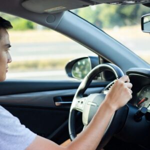 Posso dirigir o carro com apenas uma mão no volante? Veja o que diz a lei