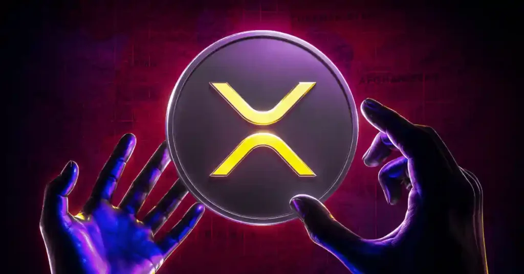 Duas mãos alcançando um token Ripple XRP prateado e amarelo brilhante contra um fundo de grade vermelho escuro.