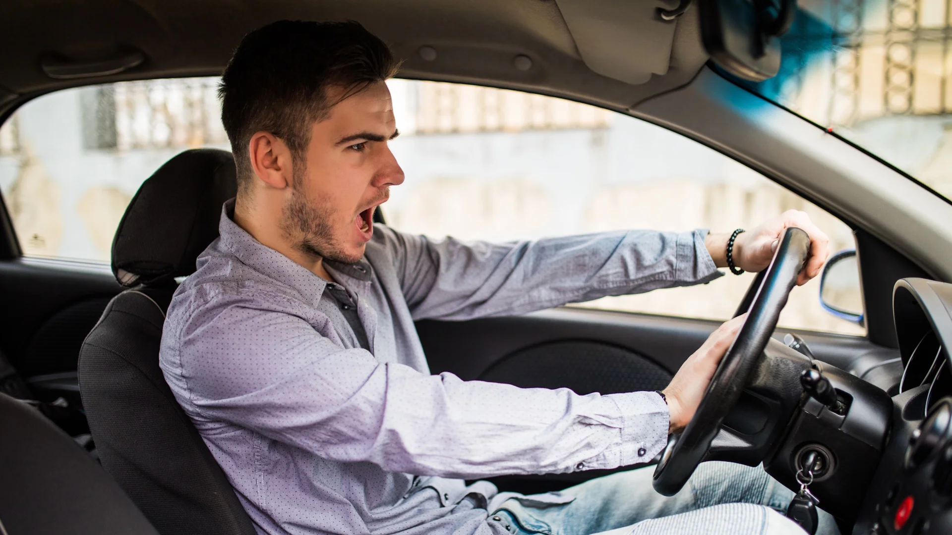 Editar informações da imagem traffic-problems-nice-emotional-man-giving-signal-while-driving-car